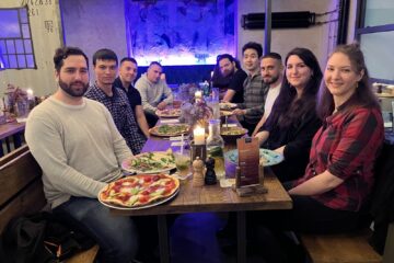 Gruppenfoto einiger NETSYNO-Teammitglieder aus Deutschland, Bulgarien und Uzbekistan am Esstisch im Restaurant